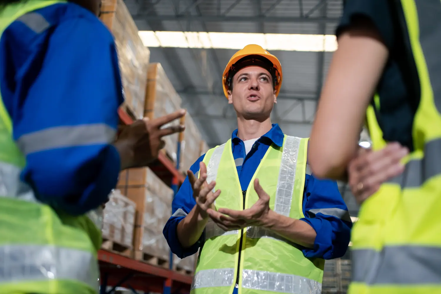 Industrielager-Diversity-Ingenieur oder Arbeiter-Mann und -Frau treffen sich bei der Zusammenarbeit, reden miteinander und überprüfen die Lagerbestände